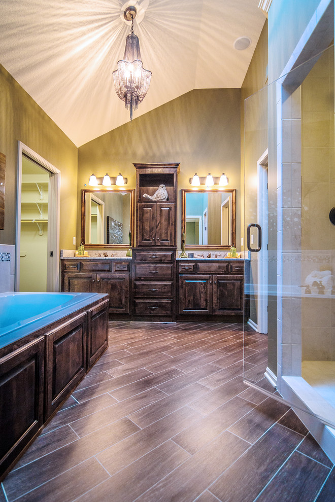 Inspiration for a large traditional master bathroom in Kansas City with an undermount sink, raised-panel cabinets, medium wood cabinets, granite benchtops, a drop-in tub, brown tile, ceramic tile, green walls and ceramic floors.