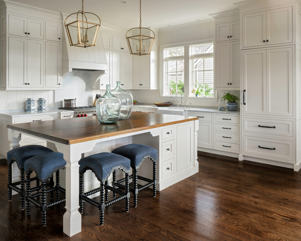 Inspiration for a large country l-shaped eat-in kitchen in Jacksonville with a farmhouse sink, beaded inset cabinets, white cabinets, wood benchtops, stainless steel appliances, dark hardwood floors, with island and brown benchtop.