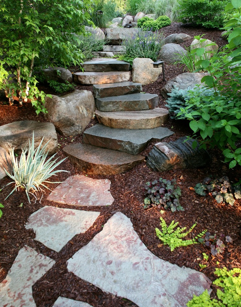 Inspiration for a mid-sized traditional backyard partial sun formal garden for spring in Minneapolis with a garden path and natural stone pavers.