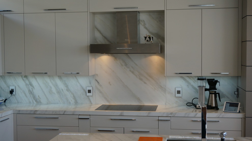 Photo of a small contemporary eat-in kitchen in Boston with an integrated sink, granite benchtops, white splashback, stone tile splashback, white appliances, medium hardwood floors and with island.