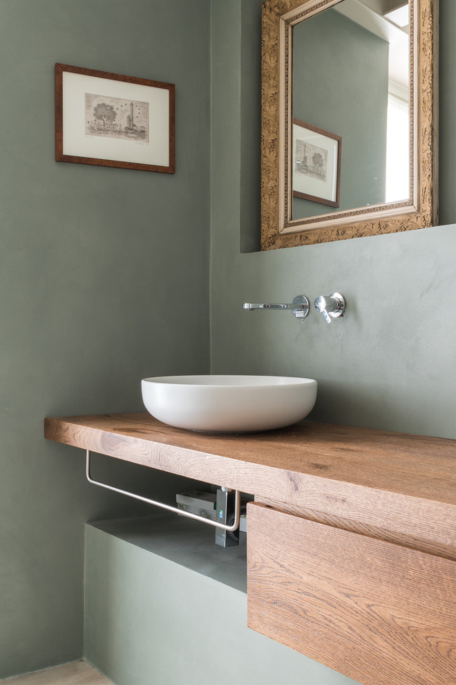 This is an example of a contemporary powder room in Other with flat-panel cabinets, medium wood cabinets, grey walls, a vessel sink and wood benchtops.