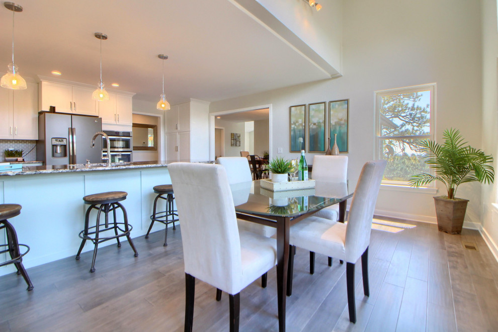 This is an example of a mid-sized contemporary open plan dining in Miami with white walls, medium hardwood floors, no fireplace and brown floor.