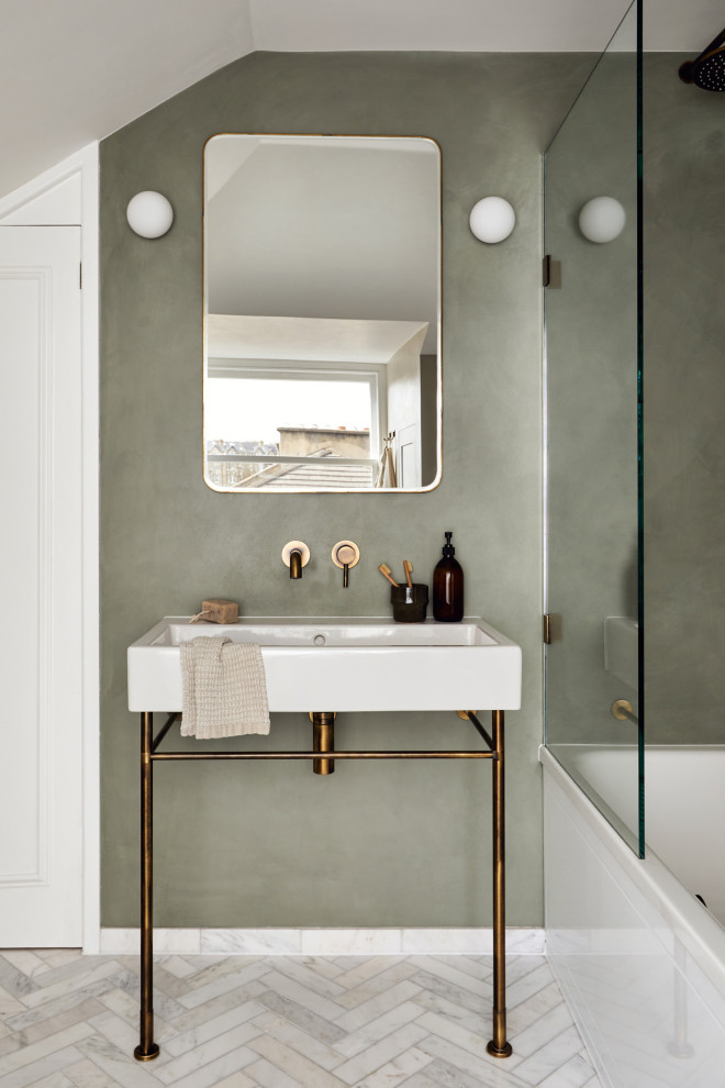 This is an example of a medium sized contemporary family bathroom in London with a built-in bath, a shower/bath combination, marble flooring, a pedestal sink, a hinged door, a single sink, a floating vanity unit and a vaulted ceiling.