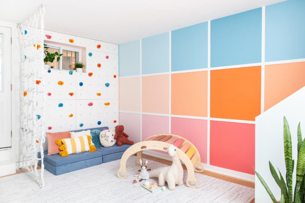 Modern inredning av ett mellanstort könsneutralt barnrum för 4-10-åringar och kombinerat med lekrum, med flerfärgade väggar, mellanmörkt trägolv och brunt golv