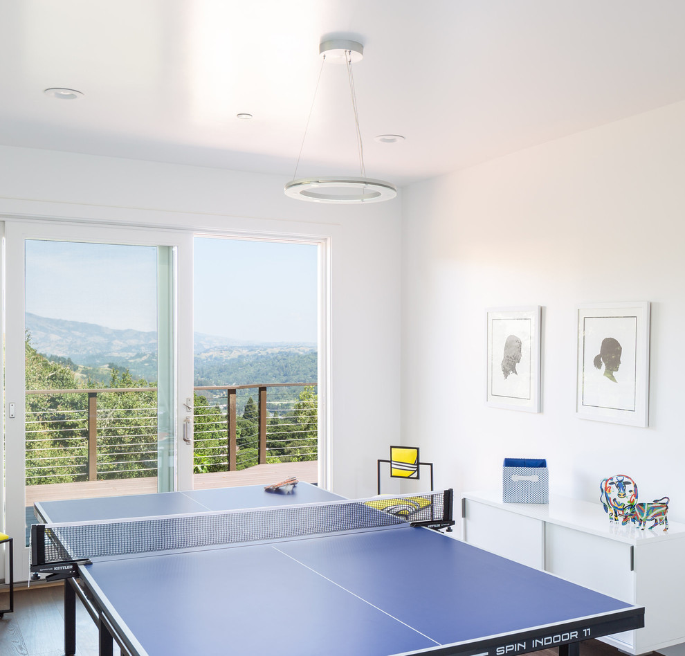 This is an example of a contemporary enclosed family room in San Francisco with a game room and white walls.