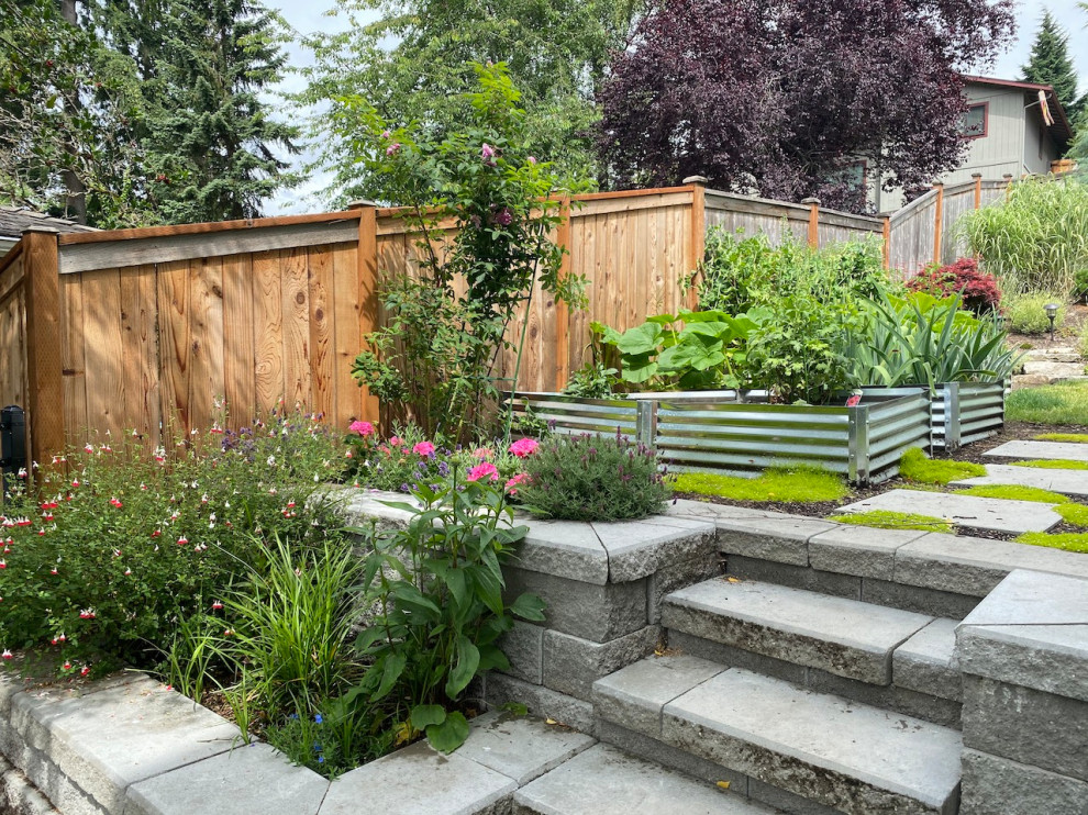 Medium sized bohemian side full sun garden steps for summer in Seattle with concrete paving and a wood fence.