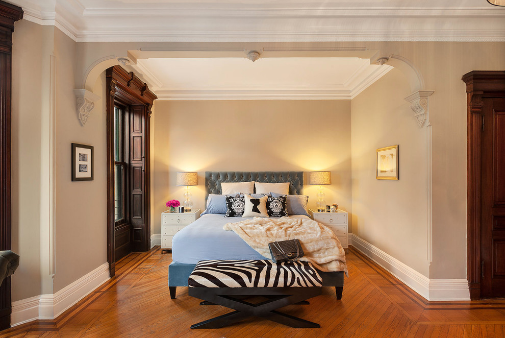 Photo of a transitional bedroom in New York with beige walls and dark hardwood floors.