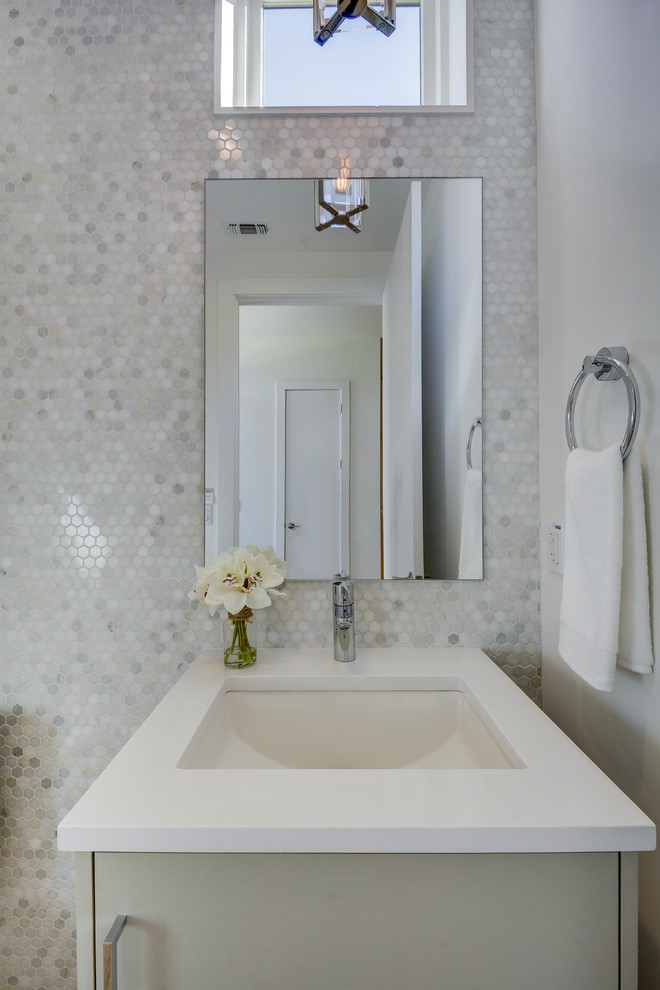 Design ideas for a modern powder room in Austin with flat-panel cabinets, grey cabinets, a two-piece toilet, gray tile, marble, white walls, light hardwood floors, an undermount sink and engineered quartz benchtops.