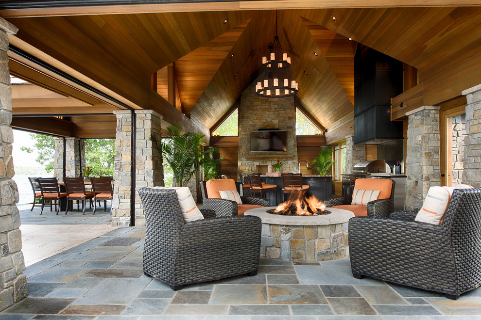 Inspiration for a country patio in Minneapolis with a fire feature and a roof extension.