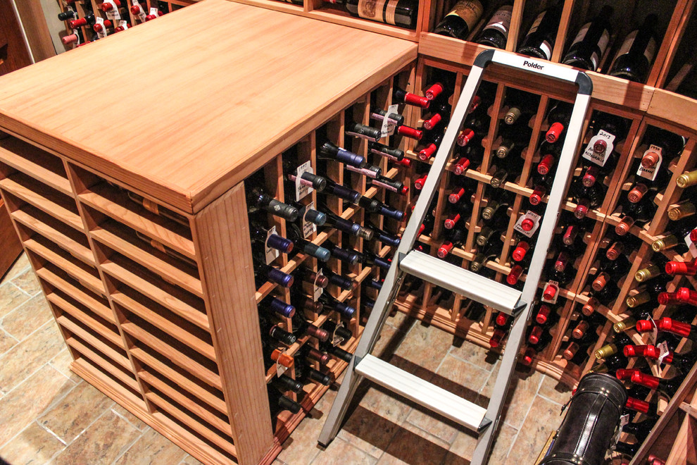 Photo of a small arts and crafts wine cellar in New York with ceramic floors and display racks.