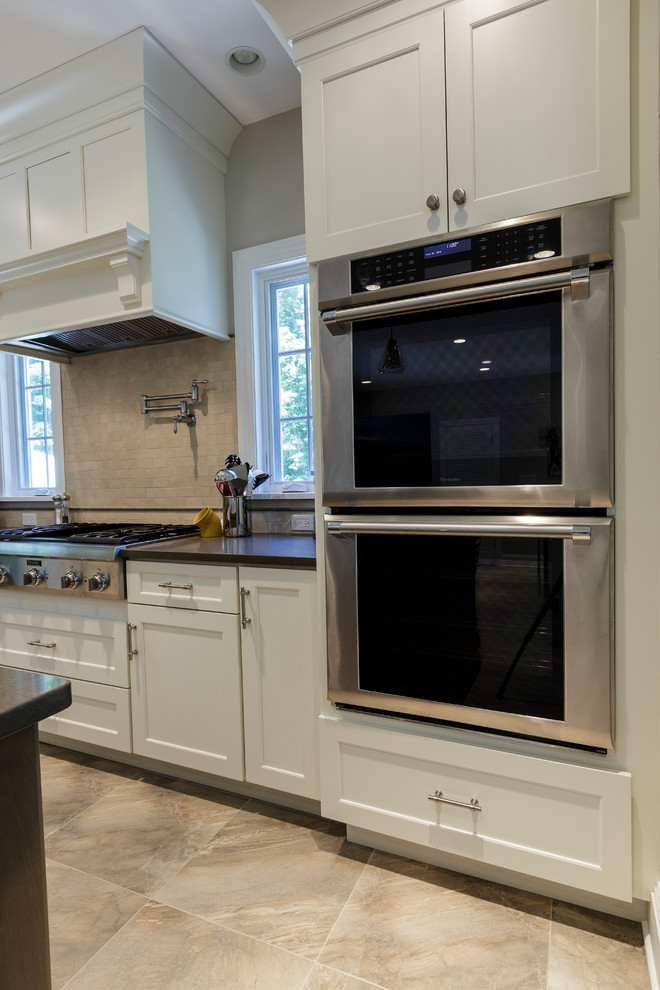 Inspiration for a mid-sized rustic l-shaped porcelain tile and beige floor open concept kitchen remodel in Bridgeport with an undermount sink, shaker cabinets, white cabinets, granite countertops, beige backsplash, porcelain backsplash, stainless steel appliances and an island