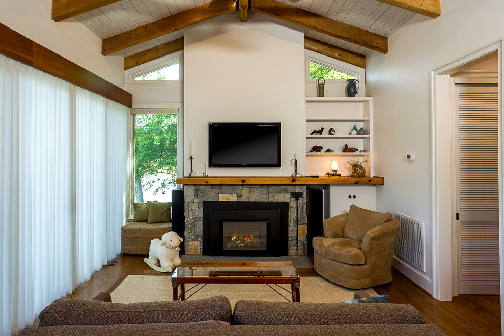 Mid-sized modern open concept living room in Other with white walls, light hardwood floors, a standard fireplace, a stone fireplace surround, a wall-mounted tv and brown floor.