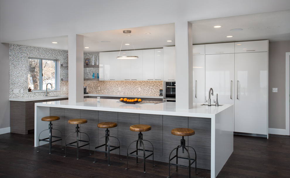 Design ideas for a large contemporary l-shaped eat-in kitchen in Salt Lake City with an undermount sink, flat-panel cabinets, beige splashback, mosaic tile splashback, stainless steel appliances, dark hardwood floors, with island, brown floor, white cabinets and quartzite benchtops.