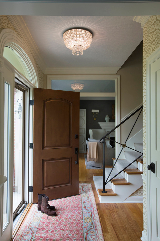 Photo of a mid-sized traditional foyer in Other with multi-coloured walls, medium hardwood floors, a single front door and a dark wood front door.