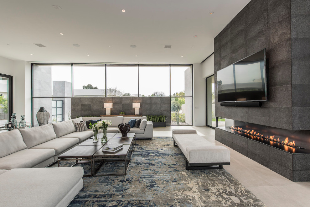 Inspiration for a large modern open concept living room in Phoenix with white walls, porcelain floors, a hanging fireplace, a stone fireplace surround, a wall-mounted tv and beige floor.