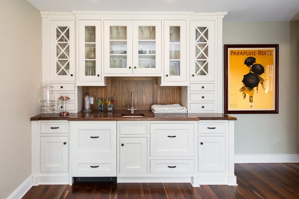 This is an example of a mid-sized traditional galley kitchen pantry in New York with a drop-in sink, beaded inset cabinets, white cabinets, marble benchtops, stainless steel appliances, dark hardwood floors and no island.