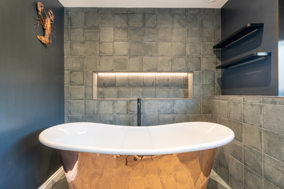 Example of a mid-sized trendy kids' beige tile and porcelain tile porcelain tile, gray floor and single-sink freestanding bathtub design in Kent with a one-piece toilet, gray walls and a wall-mount sink