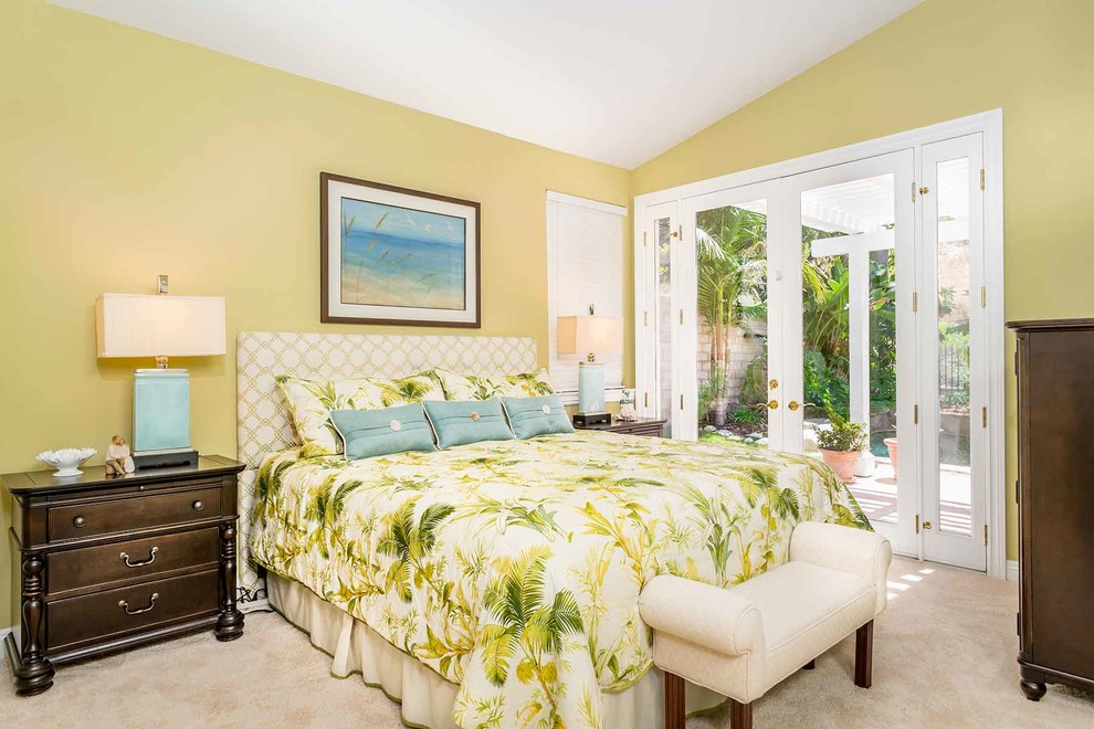 This is an example of a small beach style guest bedroom in Los Angeles with green walls, carpet, no fireplace and beige floor.