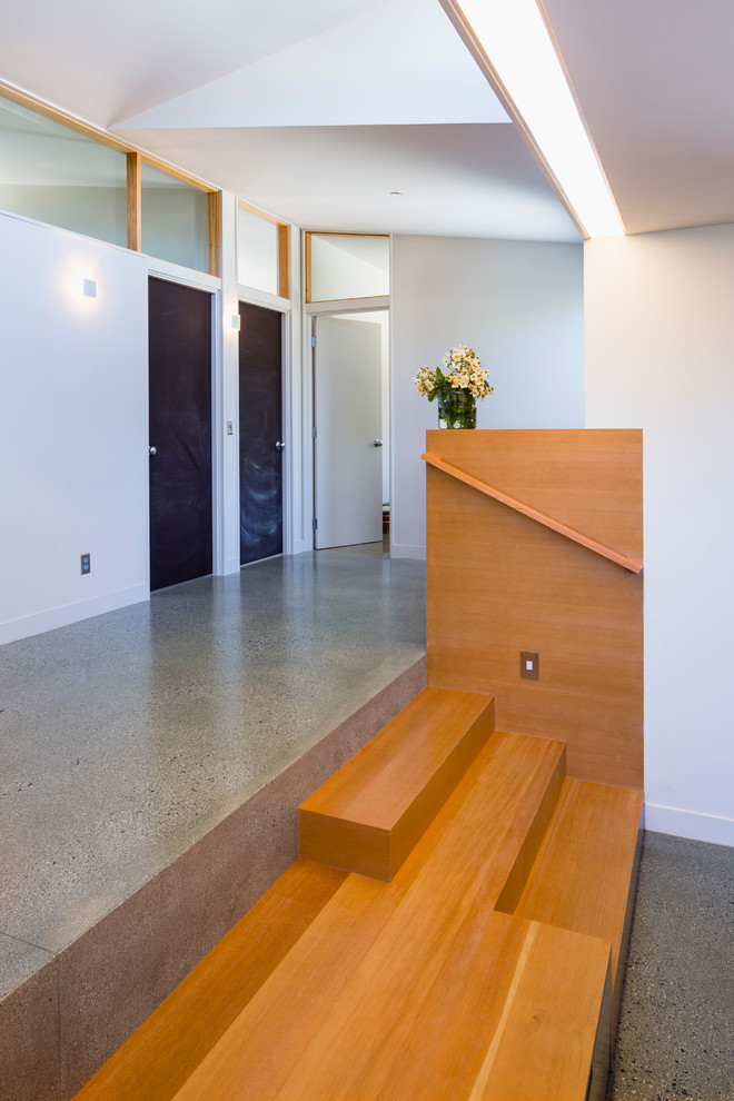 This is an example of a contemporary hallway in San Francisco with white walls and concrete floors.