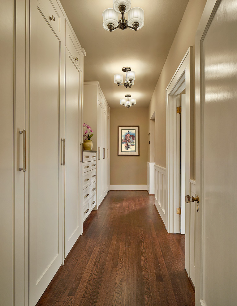 Design ideas for a mid-sized traditional gender-neutral walk-in wardrobe in Dallas with shaker cabinets, white cabinets, dark hardwood floors and brown floor.