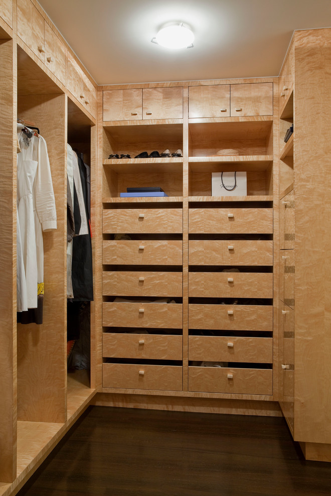 Design ideas for a contemporary gender-neutral walk-in wardrobe in New York with flat-panel cabinets, beige cabinets, dark hardwood floors and brown floor.