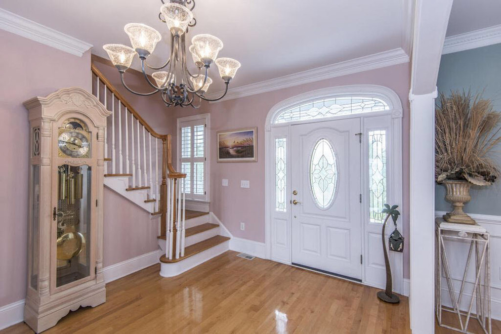Mid-sized traditional foyer in Orlando with pink walls, light hardwood floors, a single front door, a white front door and brown floor.