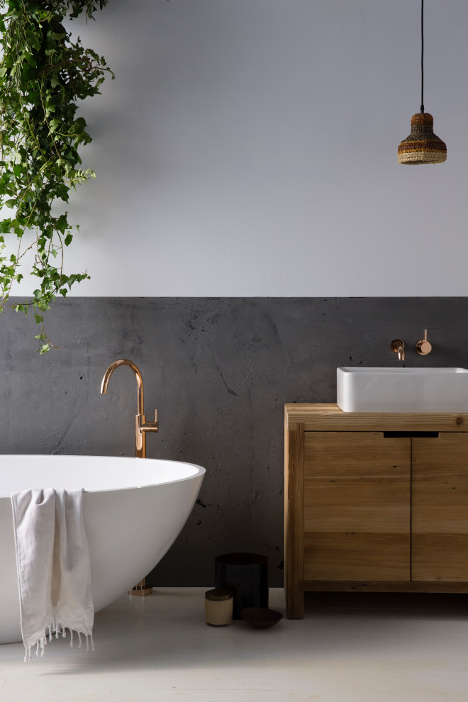 This is an example of a large contemporary master bathroom in Auckland with brown cabinets, a freestanding tub, gray tile, cement tile, white walls, a vessel sink, wood benchtops, white floor, brown benchtops, a single vanity and a freestanding vanity.