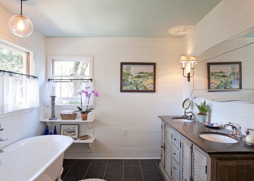 Inspiration for a mid-sized country master bathroom in Atlanta with an undermount sink, louvered cabinets, medium wood cabinets, soapstone benchtops, a claw-foot tub, white tile, subway tile, white walls, ceramic floors, a corner shower, black floor and a hinged shower door.