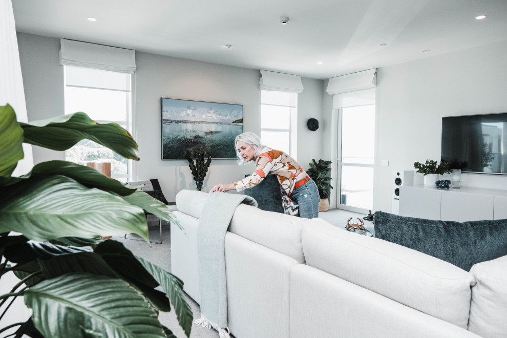 Small beach style Formal living room in Auckland With Grey Walls, Carpet, a Wall-mounted TV and Grey Floor.