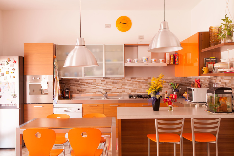 Mid-sized contemporary u-shaped open plan kitchen in Milan with a drop-in sink, orange cabinets, porcelain splashback, porcelain floors, with island, flat-panel cabinets and orange splashback.