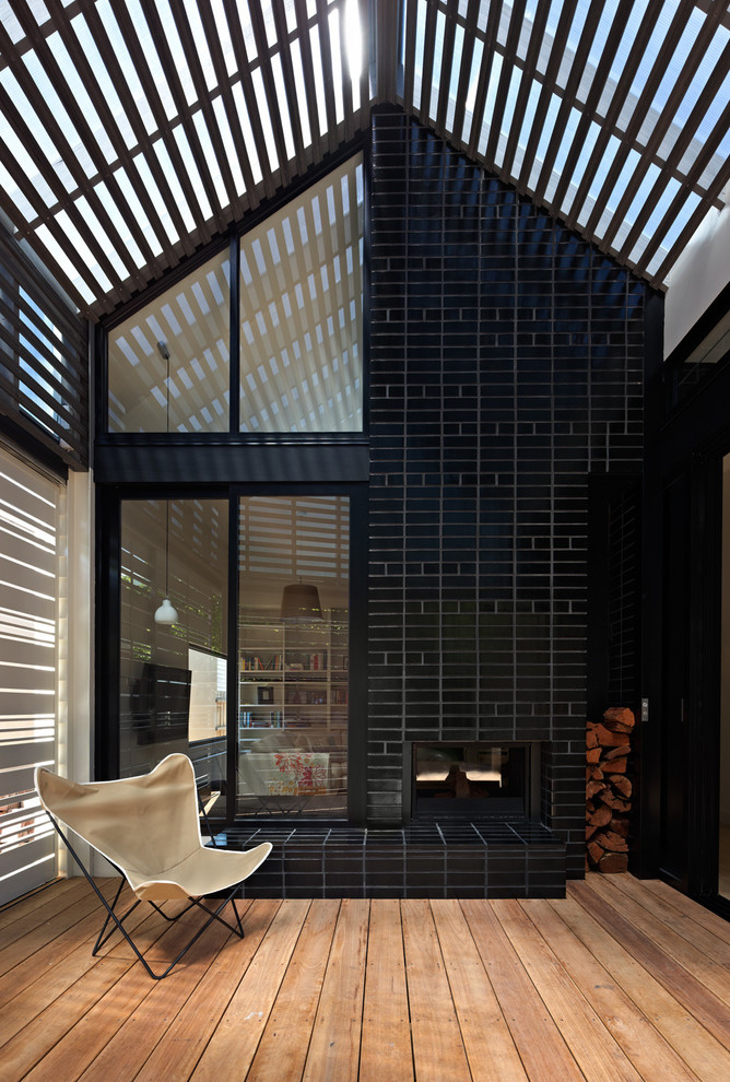 Contemporary side yard screened-in verandah in Melbourne with decking and a pergola.