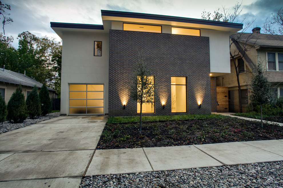 Photo of a contemporary two-storey exterior in Dallas with mixed siding.