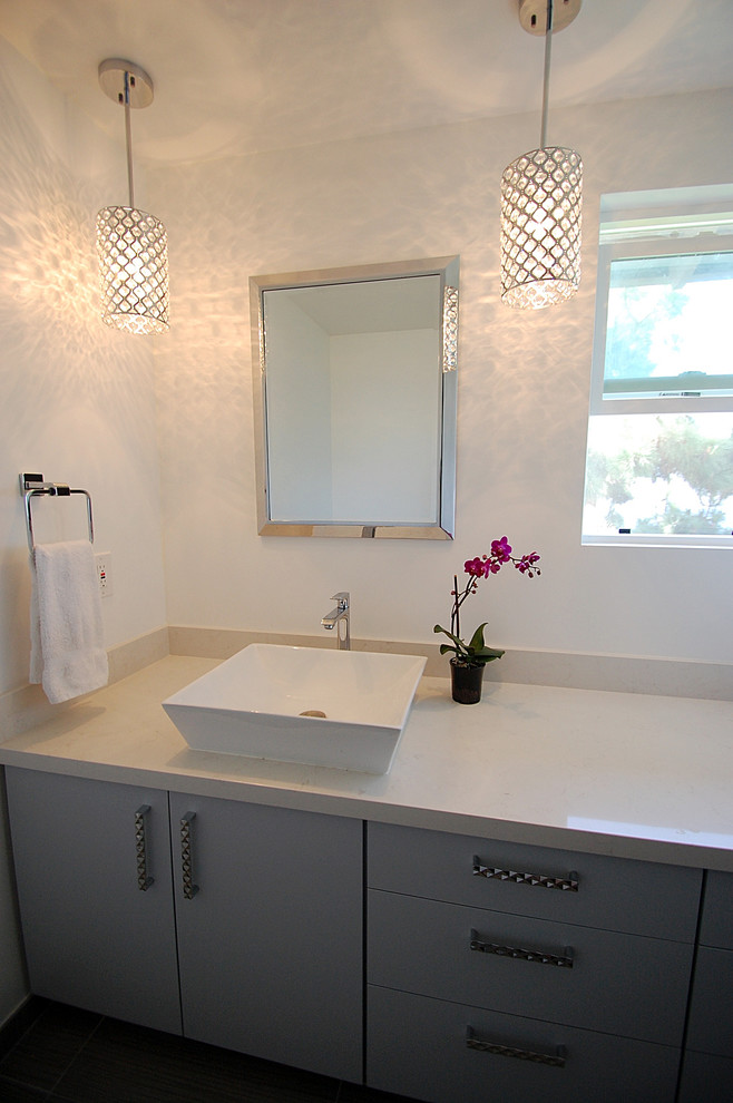 Inspiration for a small contemporary powder room in Los Angeles with a vessel sink, flat-panel cabinets, grey cabinets, engineered quartz benchtops, a two-piece toilet and white walls.