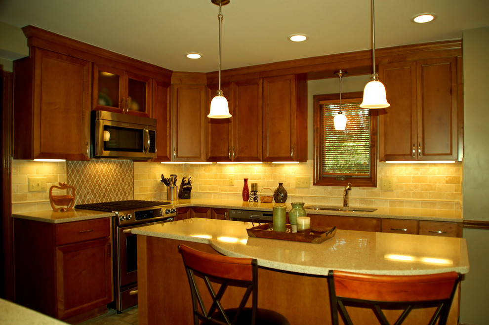 Example of a mid-sized transitional l-shaped ceramic tile eat-in kitchen design in Columbus with an undermount sink, flat-panel cabinets, medium tone wood cabinets, quartz countertops, beige backsplash, stone tile backsplash, stainless steel appliances and an island