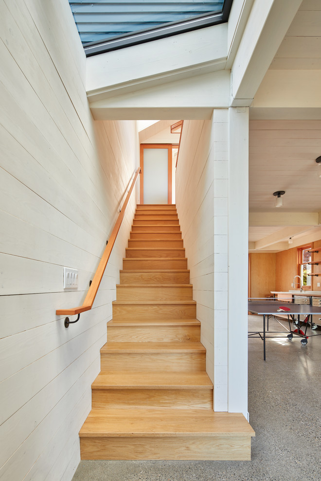 This is an example of a small contemporary wood straight staircase in Seattle with wood risers and wood railing.