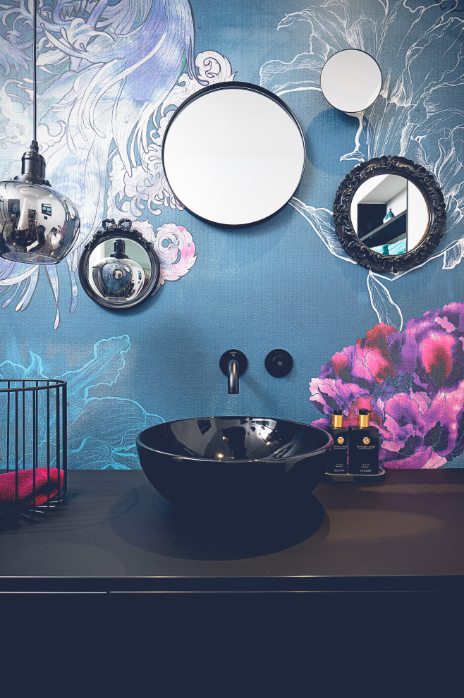 Mittelgroße Gästetoilette mit Wandtoilette mit Spülkasten, blauen Fliesen, Keramikfliesen, blauer Wandfarbe, Aufsatzwaschbecken, Waschtisch aus Holz, schwarzem Boden, schwarzer Waschtischplatte, schwebendem Waschtisch und Tapetenwänden in Düsseldorf