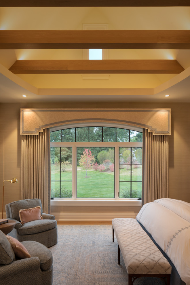 Diseño de dormitorio principal campestre con paredes beige, suelo de madera clara, suelo marrón y vigas vistas