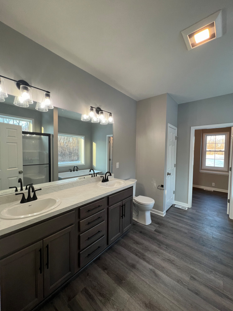 Inspiration för mellanstora klassiska vitt en-suite badrum, med luckor med infälld panel, skåp i mörkt trä, en toalettstol med hel cisternkåpa, grå väggar, laminatgolv, ett integrerad handfat, marmorbänkskiva och grått golv