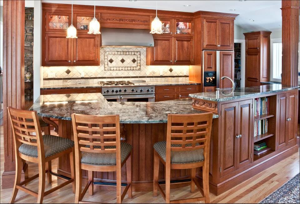Photo of a large traditional l-shaped eat-in kitchen in Boston with raised-panel cabinets, medium wood cabinets, granite benchtops, with island, an undermount sink, white splashback, ceramic splashback, stainless steel appliances and light hardwood floors.