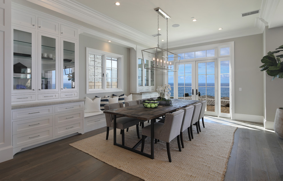 Photo of a beach style dining room in Orange County with grey walls and medium hardwood floors.