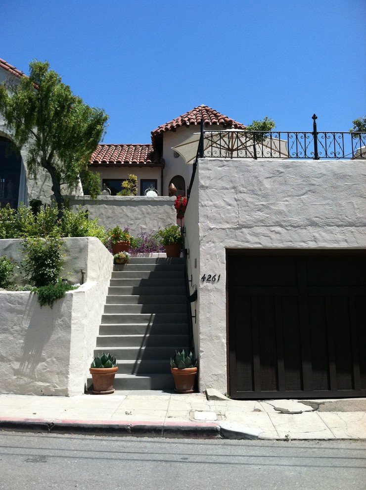 Mid-sized mediterranean white two-story stucco exterior home idea in San Diego with a tile roof and a red roof