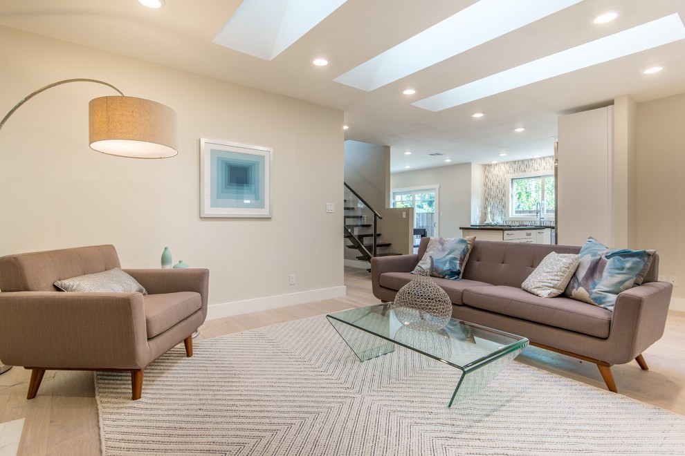 This is an example of a mid-sized modern open concept living room in San Francisco with beige walls and light hardwood floors.