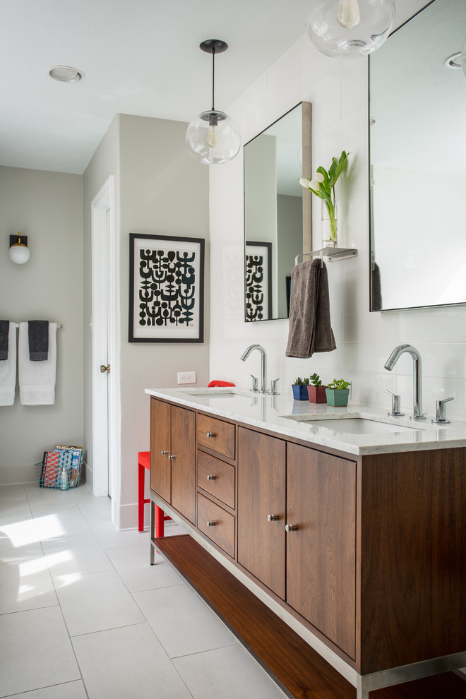 Design ideas for a mid-sized midcentury master bathroom in Dallas with brown cabinets, a freestanding tub, a corner shower, a two-piece toilet, white tile, ceramic tile, grey walls, porcelain floors, an undermount sink, marble benchtops, white floor, a hinged shower door, white benchtops and flat-panel cabinets.