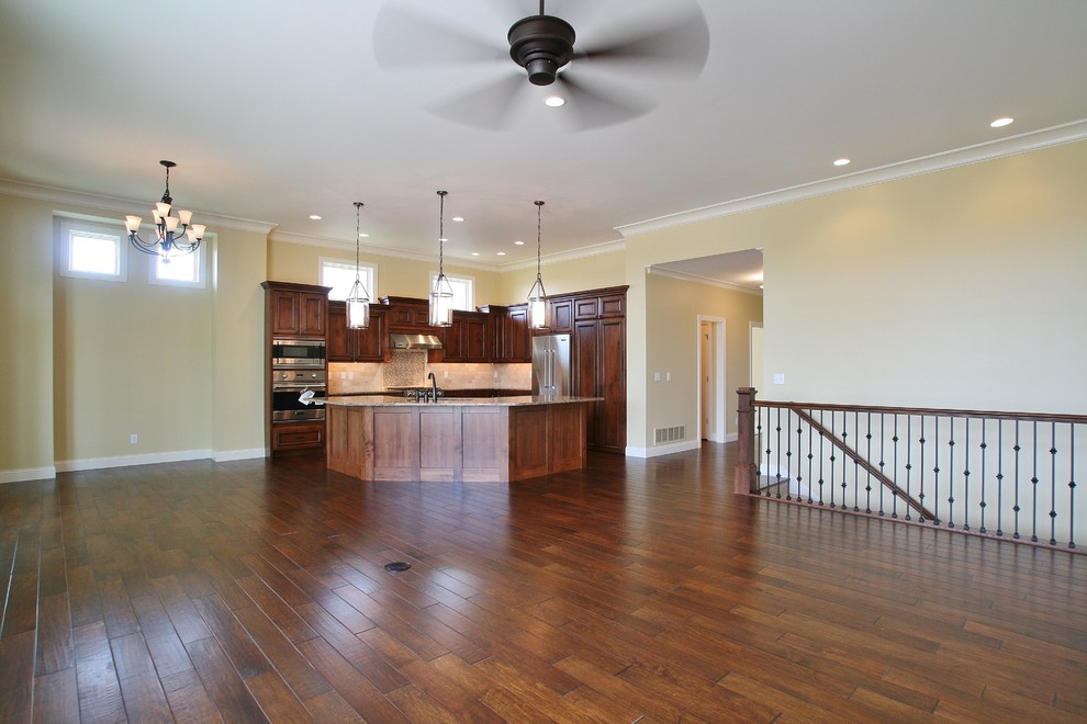 Example of a large transitional l-shaped dark wood floor and brown floor kitchen design in Chicago with an undermount sink, recessed-panel cabinets, medium tone wood cabinets, granite countertops, beige backsplash, ceramic backsplash, stainless steel appliances, an island and multicolored countertops