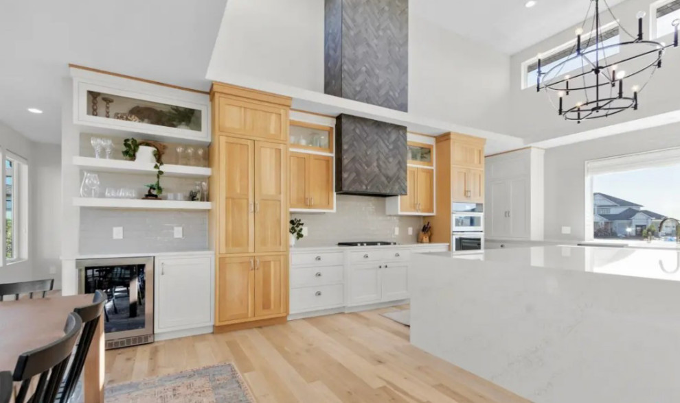 Large transitional galley light wood floor eat-in kitchen photo with recessed-panel cabinets and an island