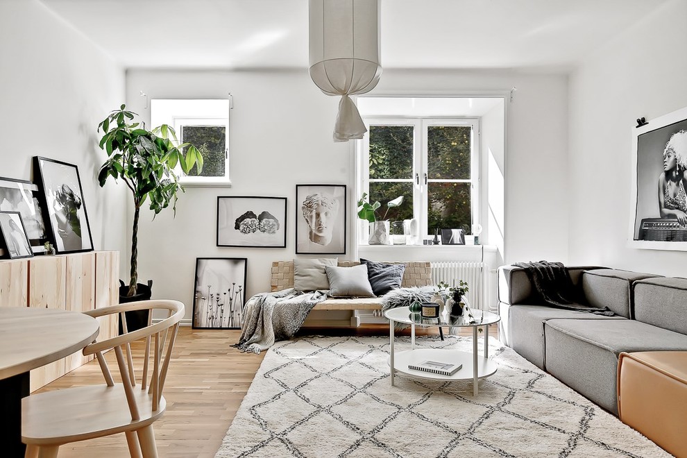 Photo of a mid-sized scandinavian formal enclosed living room in Stockholm with grey walls, light hardwood floors and no tv.