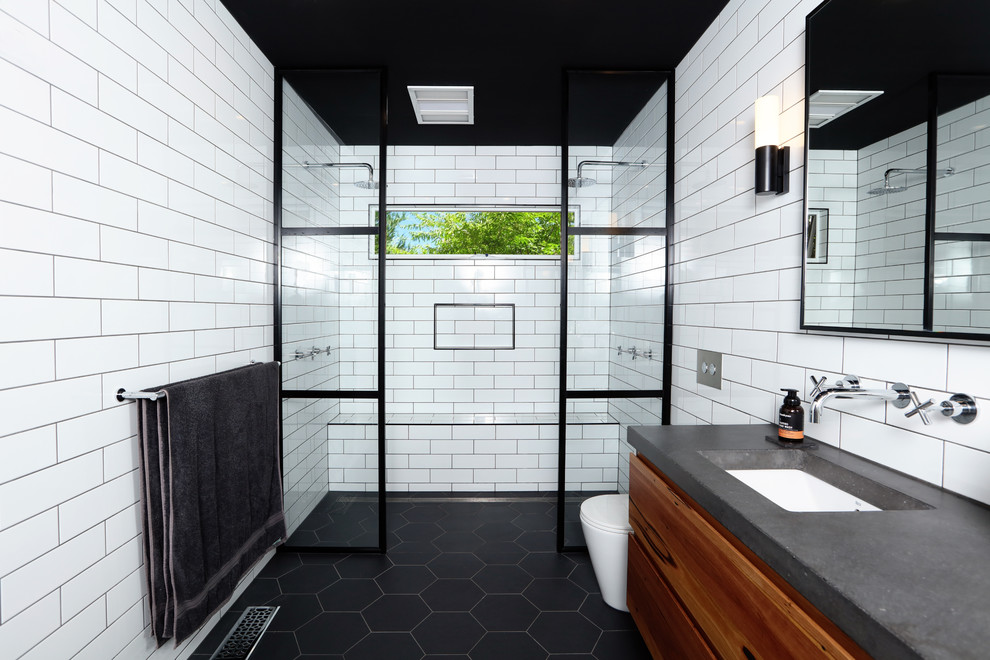 Photo of a contemporary master bathroom in Melbourne with medium wood cabinets, a double shower, white tile, subway tile, ceramic floors, an undermount sink, concrete benchtops, black floor, an open shower, white walls, grey benchtops, a shower seat, a floating vanity, brick walls, a wall-mount toilet, a double vanity and flat-panel cabinets.