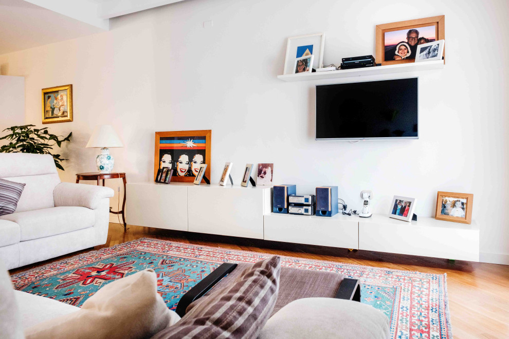 Esempio di un ampio soggiorno design aperto con libreria, pareti bianche, TV a parete, parquet scuro, pavimento marrone e con abbinamento di mobili antichi e moderni
