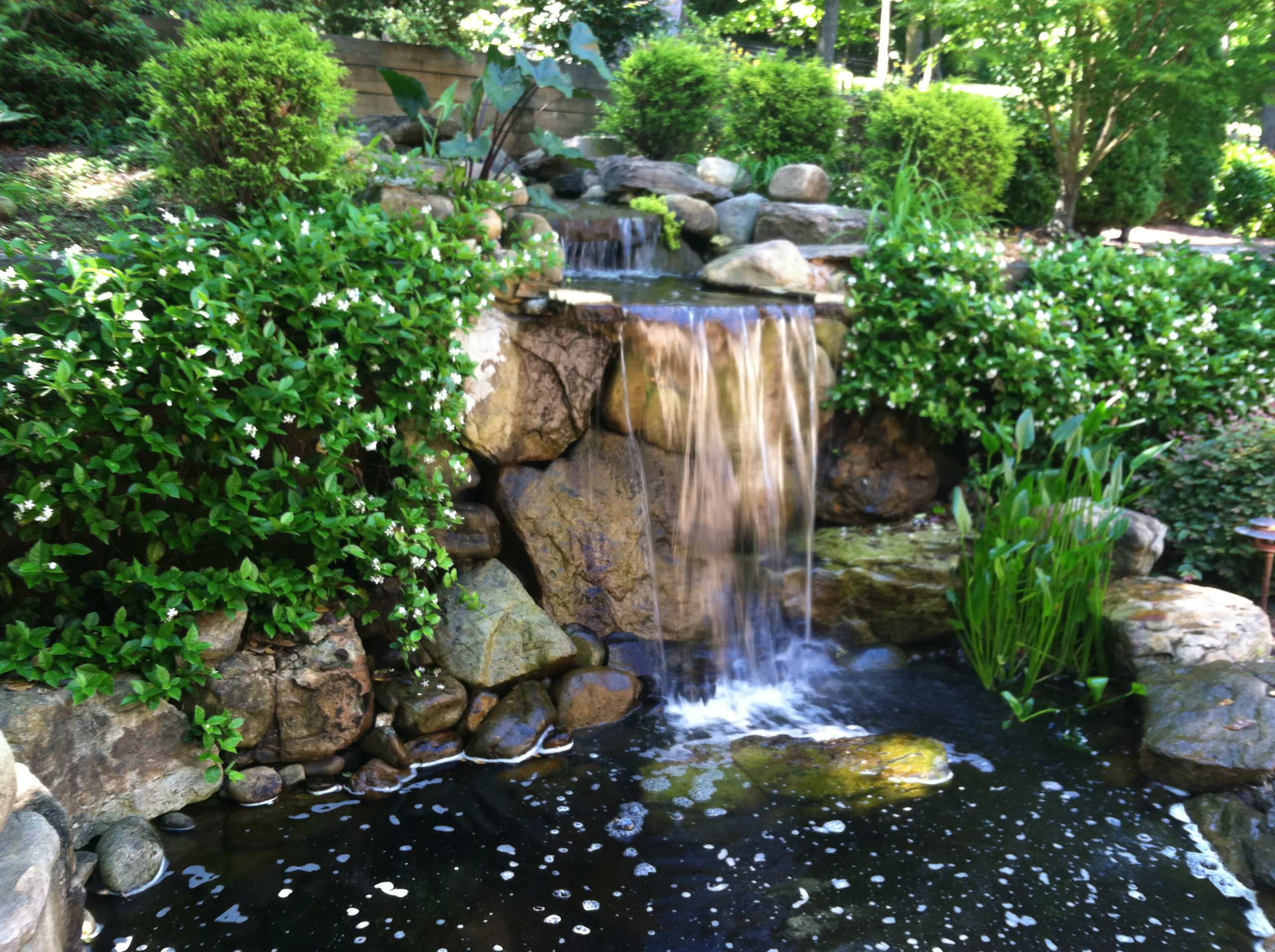 Photo of a mid-sized traditional partial sun hillside stone water fountain landscape in Charleston for summer.
