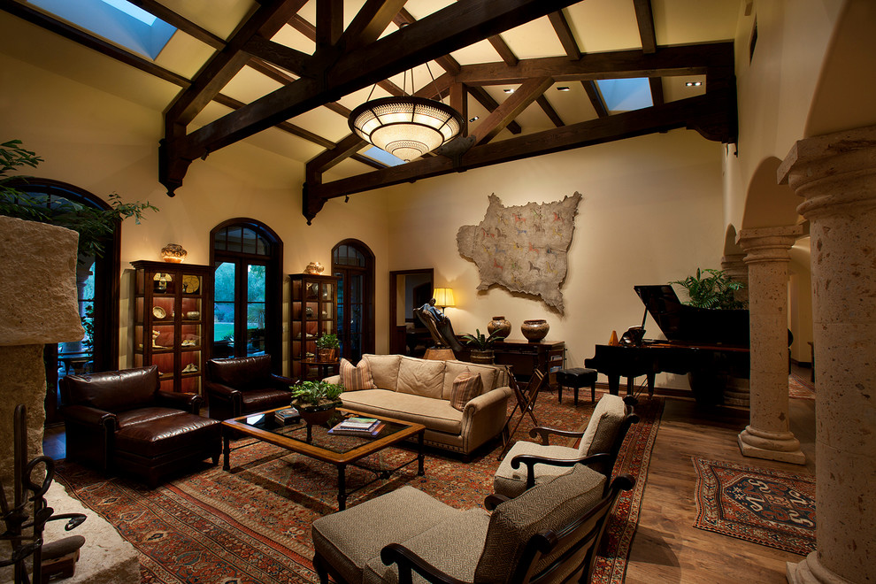 Inspiration for a mid-sized mediterranean formal open concept living room in Phoenix with beige walls, a standard fireplace, a stone fireplace surround, dark hardwood floors and no tv.